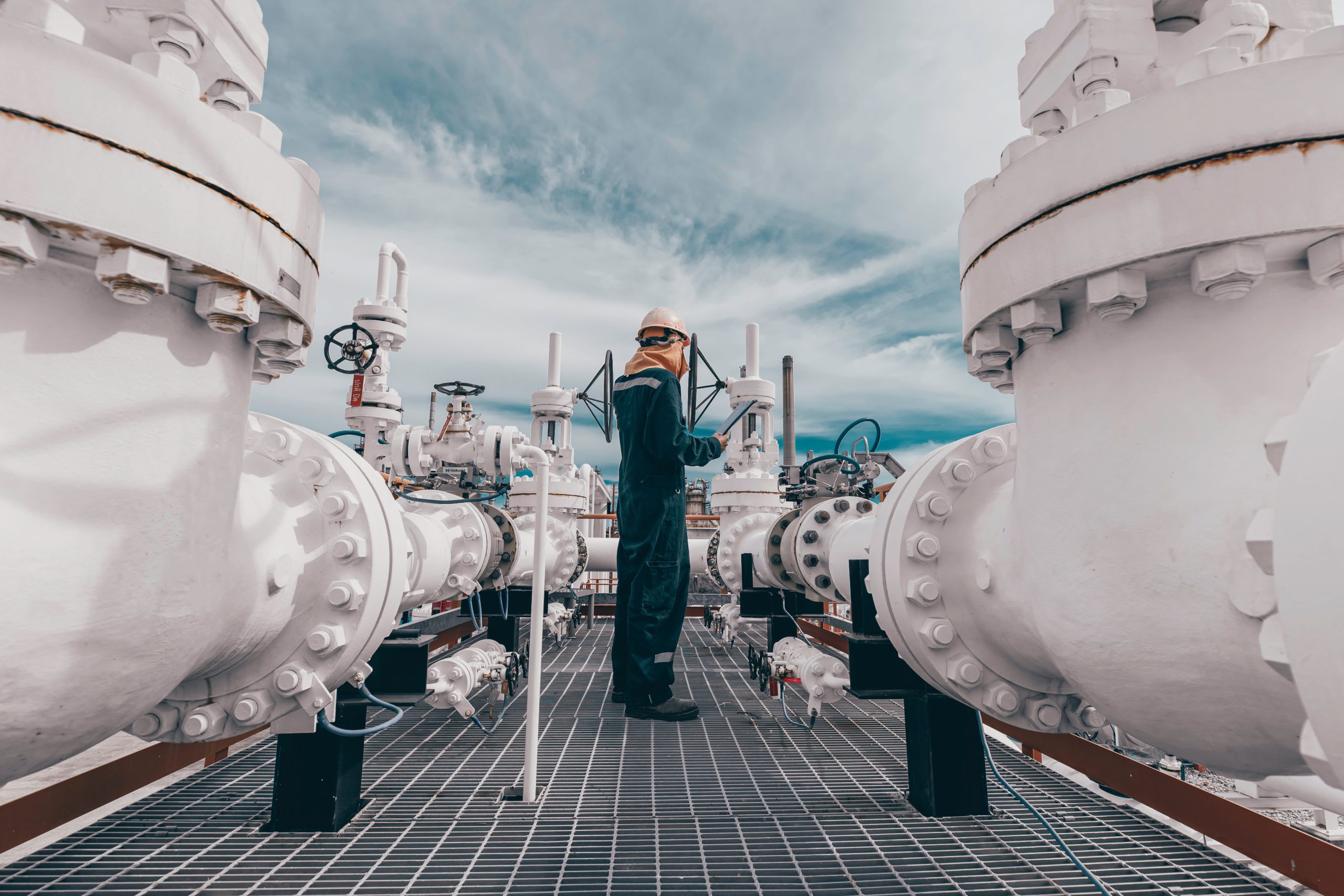 Male worker inspection at steel long pipes and pipe elbow in station oil factory during refinery valve of visual check record pipeline oil and gas